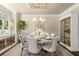 An elegant dining room with a round table set for six, a chandelier, and natural light at 580 Washington Way, Cumming, GA 30040