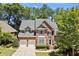 Traditional brick home with a well-manicured lawn, showcasing a two-car garage and inviting entrance at 580 Washington Way, Cumming, GA 30040
