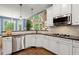 Updated kitchen featuring stainless steel appliances, a breakfast bar, and white cabinetry at 580 Washington Way, Cumming, GA 30040