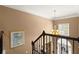 A graceful staircase, with a hanging chandelier, and a painting is seen from the second floor at 580 Washington Way, Cumming, GA 30040
