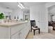 Bright bathroom featuring double sink vanity, white cabinets, and a large mirror with views to the living room at 10765 Arlington Pt, Alpharetta, GA 30022
