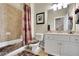 Neutral toned bathroom with combination shower and tub, white vanity, framed mirror, and tile flooring at 10765 Arlington Pt, Alpharetta, GA 30022