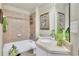 Stylish bathroom features tiled walls, a bathtub with shower, and a decorative vanity at 10765 Arlington Pt, Alpharetta, GA 30022