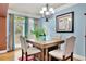 Cozy dining area with light blue walls, natural light, and stylish chandelier at 10765 Arlington Pt, Alpharetta, GA 30022