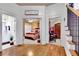 Hallway view with hardwood floors leads to a bedroom and bathroom featuring a staircase with iron railings at 10765 Arlington Pt, Alpharetta, GA 30022
