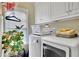 Well-organized laundry room with white cabinets, modern appliances, and natural light at 10765 Arlington Pt, Alpharetta, GA 30022
