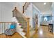 Bright staircase with hardwood steps and elegant black iron railing at 10765 Arlington Pt, Alpharetta, GA 30022