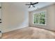 Spacious bedroom with hardwood floors, a ceiling fan, and a large window overlooking the trees at 3915 Ashley Trace Sw Ct, Lilburn, GA 30047