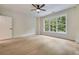 Well-lit bedroom showcasing hardwood floors, a ceiling fan, and a window with views of the greenery outside at 3915 Ashley Trace Sw Ct, Lilburn, GA 30047