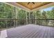 Spacious covered deck with wood-plank floor and view of the surrounding lush green forest at 3915 Ashley Trace Sw Ct, Lilburn, GA 30047