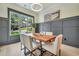 Stylish dining room with wainscoting, modern light fixture, and large window views at 3915 Ashley Trace Sw Ct, Lilburn, GA 30047