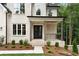 Inviting covered front porch with brick steps, dark wood columns, and wrought iron railing at 3915 Ashley Trace Sw Ct, Lilburn, GA 30047