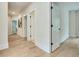 A hallway with neutral paint, white trim, hardwood floors and several doors at 3915 Ashley Trace Sw Ct, Lilburn, GA 30047