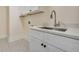 Laundry room showcasing white cabinets, a sink, and decorative patterned tile flooring at 3915 Ashley Trace Sw Ct, Lilburn, GA 30047