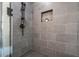 A shower with a grey tile surround, a shower niche, a rain head and a handheld at 3915 Ashley Trace Sw Ct, Lilburn, GA 30047