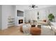 Bright living room featuring a cozy fireplace, modern ceiling fan, and hardwood floors at 415 Mayfair Ct, Alpharetta, GA 30009