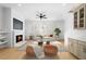Bright living room featuring a cozy fireplace, modern ceiling fan, and hardwood floors at 415 Mayfair Ct, Alpharetta, GA 30009