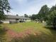 Large backyard featuring a well-kept lawn, wooden fencing, and a single-Gathering home's rear facade at 4284 Village Green W Cir, Conyers, GA 30013