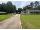 A well-maintained front yard with lush green grass, a long driveway, and an American style single Gathering home at 4284 Village Green W Cir, Conyers, GA 30013