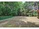 Expansive backyard featuring a level grassy area surrounded by mature trees and landscaping at 5742 Riverside Walk Dr, Sugar Hill, GA 30518