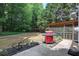 Backyard area with a grill, screened-in porch, an outdoor play area and wooded surroundings at 5742 Riverside Walk Dr, Sugar Hill, GA 30518