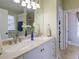 Bathroom with a double vanity, stone countertops, decorative fixtures, and tiled flooring and walk-in closet at 5742 Riverside Walk Dr, Sugar Hill, GA 30518