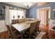 Dining room featuring hardwood floors, wainscoting, modern chandelier, and a large table with seating at 5742 Riverside Walk Dr, Sugar Hill, GA 30518