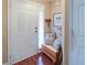 Cozy entryway featuring hardwood floors, bench with pillows, and a white door with decorative wreath at 5742 Riverside Walk Dr, Sugar Hill, GA 30518