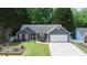 Inviting single-story home with blue siding, red shutters, well-manicured lawn, and a two-car garage at 5742 Riverside Walk Dr, Sugar Hill, GA 30518