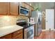Well-equipped kitchen features stainless steel appliances and beautiful hardwood floors at 5742 Riverside Walk Dr, Sugar Hill, GA 30518
