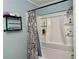 Bright bathroom features a shower/tub combo, modern shower head, and a black rack for storage at 11072 Shannon Cir, Hampton, GA 30228