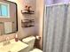 Cozy bathroom with modern fixtures, stylish shelves, and a neatly arranged shower curtain at 11072 Shannon Cir, Hampton, GA 30228