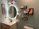 Well-lit bathroom features an LED mirror, modern vanity and handy wall-mounted shelves for storage at 11072 Shannon Cir, Hampton, GA 30228