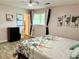 Bright bedroom featuring laminate flooring, a comfortable queen bed, and a well-lit atmosphere at 11072 Shannon Cir, Hampton, GA 30228