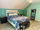 Bright bedroom with sloped ceilings features a queen bed and colorful floral comforter at 11072 Shannon Cir, Hampton, GA 30228