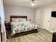 Bright bedroom featuring laminate flooring, comfortable queen bed, and a well-lit atmosphere at 11072 Shannon Cir, Hampton, GA 30228