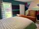 Spacious bedroom with a cozy bed, unique wall decorations, laminate flooring, and natural light at 11072 Shannon Cir, Hampton, GA 30228