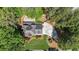 Aerial view of a home surrounded by lush greenery, showcasing the driveway and outdoor living space at 4320 Oklahoma Nw Way, Kennesaw, GA 30152