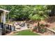 Backyard deck with patio furniture surrounded by lush greenery and stone walls, creating a private oasis at 4320 Oklahoma Nw Way, Kennesaw, GA 30152