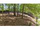 Wooded backyard featuring a sloped lawn, mature trees, and a wooden privacy fence at 4320 Oklahoma Nw Way, Kennesaw, GA 30152