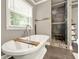 This bathroom features a soaking tub, large window with blinds, and tiled shower with a bench at 4320 Oklahoma Nw Way, Kennesaw, GA 30152