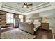 This bedroom features a decorative wood wall, tray ceiling, stylish ceiling fan and a plush rug at 4320 Oklahoma Nw Way, Kennesaw, GA 30152