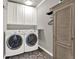 This laundry room features a front load washer and dryer, cabinets, and stylish accents at 4320 Oklahoma Nw Way, Kennesaw, GA 30152