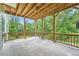 Covered back porch with wood columns and concrete flooring overlooking a wooded area at 46 Grand Georgian Ne Ct, Cartersville, GA 30121
