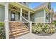 Lovely covered front porch with stone steps, wrought iron railing and complementary light green siding at 46 Grand Georgian Ne Ct, Cartersville, GA 30121