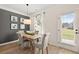 Cozy dining area with a rustic wooden table, gray upholstered chairs, and a view of the backyard through a bright window at 106 Jacobs Farm Ln # 42, Lawrenceville, GA 30045