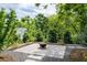 Backyard patio with fire pit, surrounded by lush trees and stone gravel at 1228 Hosea L Williams Ne Dr, Atlanta, GA 30317