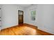 A bright bedroom with hardwood floors, white trim, and a view of the outdoors through a large window at 1228 Hosea L Williams Ne Dr, Atlanta, GA 30317
