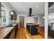 Open kitchen layout showcasing black cabinetry, butcher block counters, a central island, and hardwood floors at 1228 Hosea L Williams Ne Dr, Atlanta, GA 30317