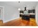 Modern kitchen with an island, dark cabinets and hardwood floors adjacent to a living space at 1228 Hosea L Williams Ne Dr, Atlanta, GA 30317